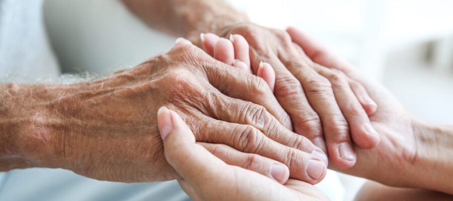 young hand holding elderly hand